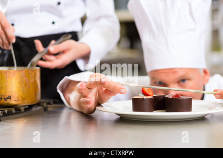 Koch, Konditor, im Hotel oder Restaurant Küche kochen, er ist ein süßes Dessert finishing Stockfoto