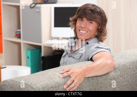 Mann auf einer Couch sitzen und Lächeln Stockfoto