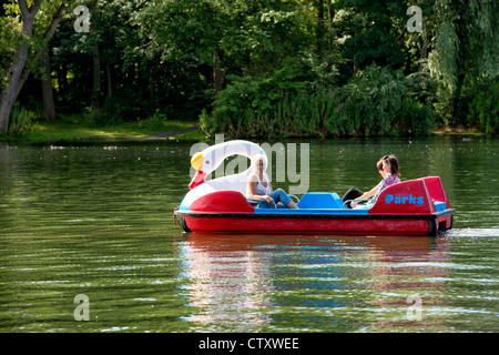 Drei junge Frauen im Schwan geformt Sportboote auf einem See im Stanley Park, Blackpool Stockfoto