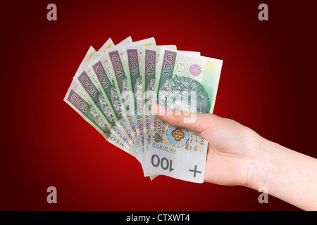 Hand mit polnischen Geld auf rotem Grund Stockfoto