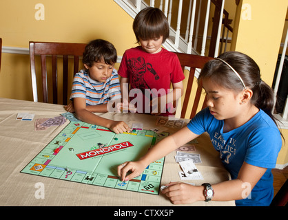 Multi-ethnischen Gruppe befreundeter Hispanic und asiatischen spielen Brettspiel Monopoly zu Hause während der Sommerferien Stockfoto