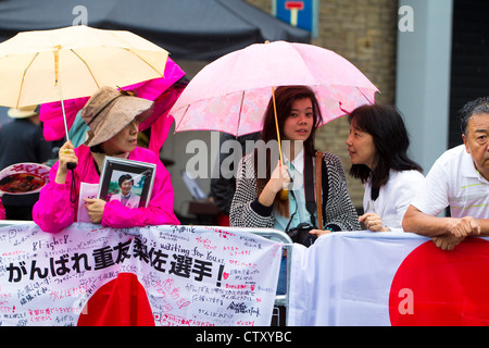 Japanische Leichtathletik-Fans warten im Regen für Frauen Marathon, Olympische Spiele, London 2012. Stockfoto