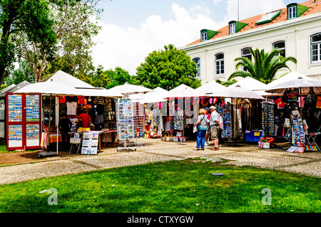 Touristen auf der Suche um gut bestückt und bunten Souvenirstände auf einem Stein gepflasterte Terrasse in Santa Maria de Belém, Lissabon Stockfoto