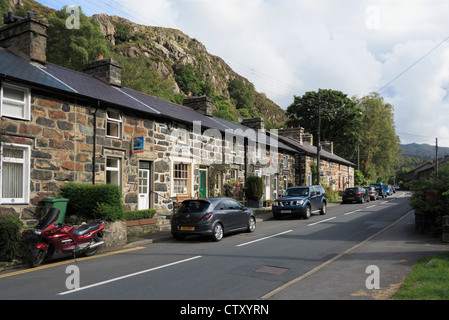 Reihe von Reihenhäusern mit Autos parkten außerhalb auf schmalen Hauptstraße durch Beddgelert in Snowdonia National Park North Wales UK Stockfoto