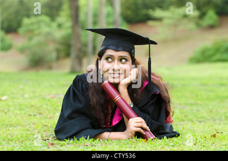 indische weibliche Absolventen mit Verlegung und zum Nachdenken über Zukunftsperspektiven Stockfoto