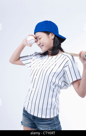 Eine weibliche Baseball-Spieler mit einem Ball und Schläger Stockfoto