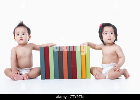 Babys, die herumsitzen und die Bücher Stockfoto