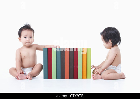 Babys, die herumsitzen und die Bücher Stockfoto