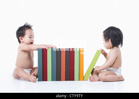 Babys, die herumsitzen und die Bücher Stockfoto