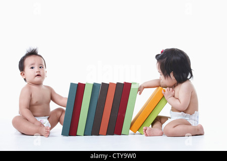 Babys, die herumsitzen und die Bücher Stockfoto