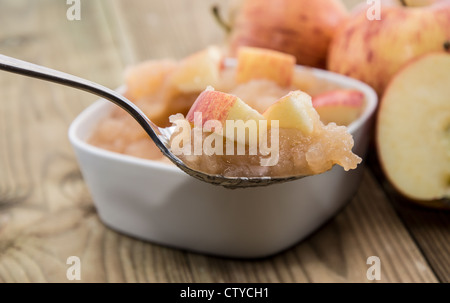 Apfelmus auf einem Löffel auf hölzernen Hintergrund Stockfoto