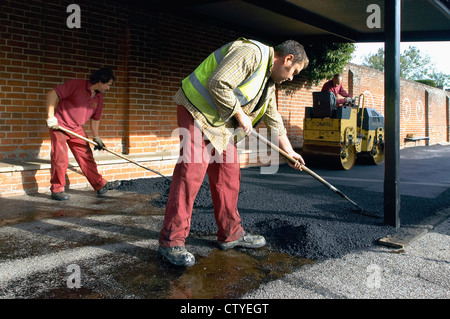 Verbreitung und heißen Asphalt mit Vibrations Walze rollt. Stockfoto