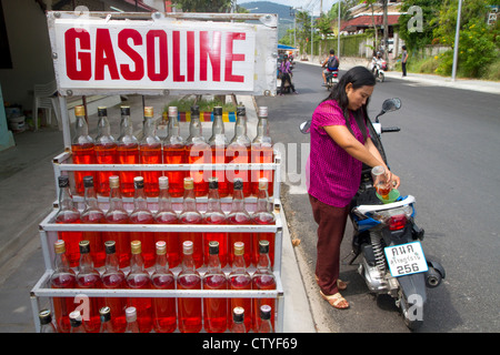 Benzin in einem Liter Whiskeyflaschen an Chaweng Beach Village auf der Insel Ko Samui, Thailand verkauft. Stockfoto