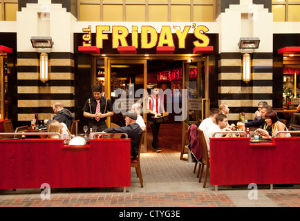 Kellner, Dienst am Menschen Essen in TGI Fridays Restaurant, die O2 Arena, London UK Stockfoto