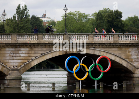 Triathleten überfahren Serpentine Brücke im Londoner Hyde Park für den Herren-Triathlon-Wettbewerb während der Olympiade 2012 in London, die 30. Olympiade. Serpentine Brücke markiert die Grenze zwischen dem Hyde Park und Kensington Gardens. Die Triathlon-Konkurrenten rasten über 1,5 km Schwimmen, ein 43km-Rennen und eine 10km run - Team GB Alistair Brownlee, Spaniens Javier Gomez und Jonathan Brownlee (Bruder des Gewinners) errang. (Weitere Beschriftungen in Beschreibung)... Stockfoto