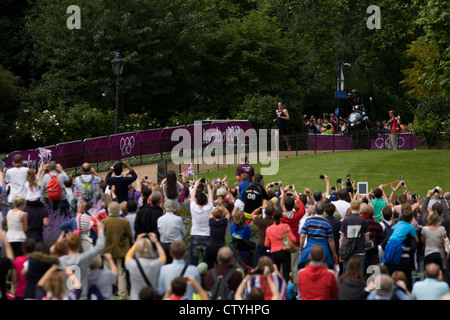 Angefeuert von einem ekstatischen Heimpublikum, durchzieht Team GB Triathlet Jonathan Brownlee Londoner Hyde Park für den Herren Triathlon-Wettkampf im Hyde Park für seine Bronze Medaille Platz während der Olympiade 2012 in London, die 30. Olympiade. Die Triathlon-Konkurrenten rasten über 1,5 km Schwimmen, ein 43km-Rennen und eine 10km run - Team GB Alistair Brownlee, Spaniens Javier Gomez und Jonathan Brownlee (Bruder des Gewinners) errang. (Weitere Beschriftungen in Beschreibung)... Stockfoto