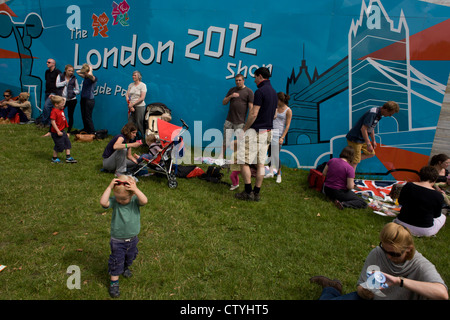 Familien Verweilen im Hyde Park nach einem anderen erfolgreichen Goldmedaille gewinnen, diesmal vom Team GB Triathlet Alistair Brownlee in der Männer Triathlon bei den Olympischen Spielen 2012 in London. Die Mitte der Woche Veranstaltung zog überraschend riesige Menschenmengen in der Hauptstadt größten öffentlichen (königlichen) Park für eine Veranstaltung, in der Regel nicht zieht Familien mit Kindern, die alle die Schönwetter und leicht Temperaturen genossen. (Weitere Beschriftungen in Beschreibung)... Stockfoto