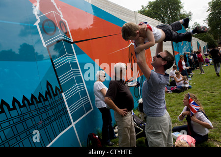 Familien Verweilen im Hyde Park nach einem anderen erfolgreichen Goldmedaille gewinnen, diesmal vom Team GB Triathlet Alistair Brownlee in der Männer Triathlon bei den Olympischen Spielen 2012 in London. Die Mitte der Woche Veranstaltung zog überraschend riesige Menschenmengen in der Hauptstadt größten öffentlichen (königlichen) Park für eine Veranstaltung, in der Regel nicht zieht Familien mit Kindern, die alle die Schönwetter und leicht Temperaturen genossen. (Weitere Beschriftungen in Beschreibung)... Stockfoto