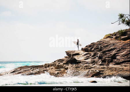 Ein Surfer auf der Landspitze am Zylinder Strand auf North Stradbroke Island in Queensland in Australien. Stockfoto