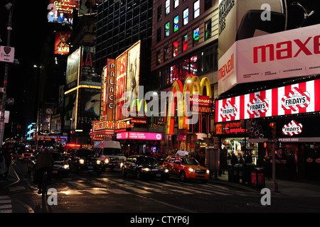 Nacht Neon anzeigen 4 Fahrspuren Scheinwerfer Autos warten Fußgängerüberweg 7th Avenue in West 46th Street, Times Square, New York Stockfoto