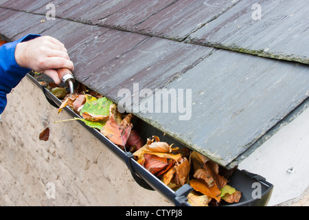 Clearing-Herbst Mann fährt vom Gosse Schieferdach Stockfoto