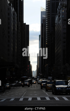 Am Nachmittag dunkle Schatten "urban Alley" zoom Porträt Autos, Verkehr, 6th Avenue von West 59th Street, Central Park South New York Stockfoto