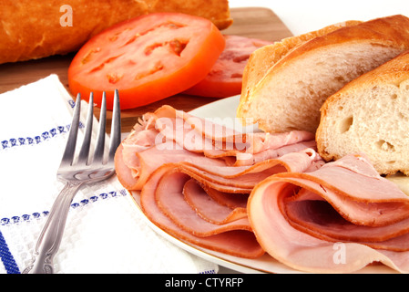 Leckeres Mittagessen mit Schinken, Brot, Käse und Tomaten mit Silber Gabel verteilen. Stockfoto