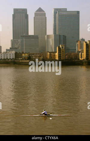 Einzelnen Schädel Ruderer vorbei Canary Wharf an der Themse, London. Stockfoto