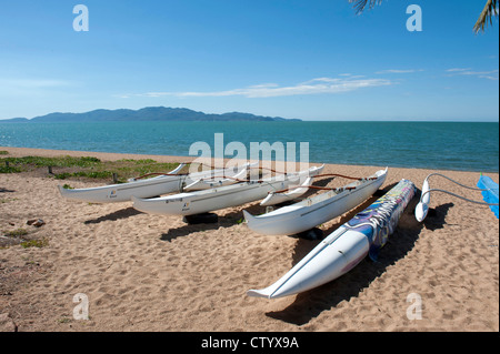 Ausleger-Kanus ruht auf den Strand von The Strand in Townsville mit Blick auf Magnetic Island über die Coral Sea Stockfoto