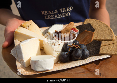 Person, die eine Auswahl an Käsesorten in Abergavenny Food Festival, Monmouthshire, Wales, UK Stockfoto