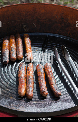 Gut gemacht Würstchen auf einer kleinen outdoor BBQ Herdplatte in Australien Stockfoto