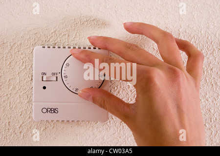 junge Frau Hand drehen/Zentralheizung Thermostat ausschalten Stockfoto