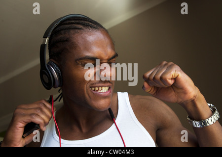 Lächelnder Mann singen mit Kopfhörer Stockfoto