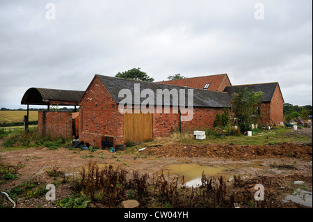 Eine umgebaute Scheune mit einem alten Traktor aus der ursprünglichen Farm im Gange Warwicksire, UK Stockfoto