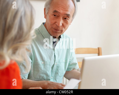 Älteres Ehepaar sprechen in Küche Stockfoto