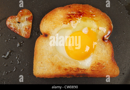 Gebratenes Brot mit einem Ei und ein Herz geformt gebratenen Kartoffeln in einer Pfanne erhitzen Stockfoto