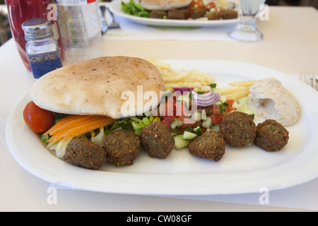 Mittagessen bestehend aus frittierten Falafel Kugeln, Salat, Pommes frites, Humus und Pita Brot in Tel Aviv, Israel Stockfoto