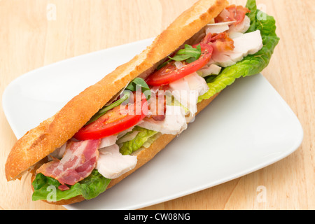 Huhn, Speck und Salat gefüllt Baguette serviert auf einem weißen Teller - Studio gedreht Stockfoto