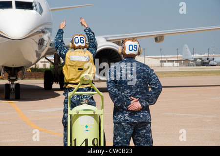 Aircrewman Mechanical Second Class David Adams, links, und Aircrewman Mechanical Second Class Sebastian Moss, rechts, zugewiesen an den Lonestar Express der Fleet Logistics Support Squadron (VR) 59 Durchfahren vor Taxi-Verfahren mit einem C-40A Clipper an Bord NAS Fort Worth JRB. Fleet Logistics Support Wing wurde gegründet, um die einzigartige Flotte der Marine Essential Airlift Flugzeuge auf weltweiter Basis zu betreiben. Die Mission der Marine bietet reaktionsschnellen, flexiblen und schnell einsetzbaren Support für die Luftlogistik und stellt 100 Prozent der intra-Theater-Luftlogistik der Marine dar. Stockfoto