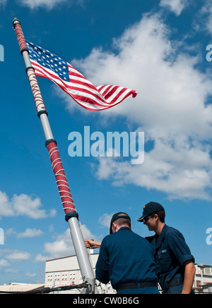 –Schiffssoldaten Seaman Apprentice Bennett Wellsandt und Schiffssoldaten Seaman Antonio Rodriguez heben die Fähnrich an Bord der geführten Raketen-Kreuzer USS Chosin (CG 65) nach dem Ziehen in Hafen während Rim of the Pacific (RIMPAC) 2012. 22 Nationen, mehr als 40 Schiffe und U-Boote, mehr als 200 Flugzeuge und 25,000 Mitarbeiter nehmen an der zweijährlichen RIMPAC-Übung vom 29. Juni bis 3. August auf und um die Hawaii-Inseln Teil. Die weltweit größte maritime Übung, RIMPAC bietet eine einzigartige Ausbildung Stockfoto