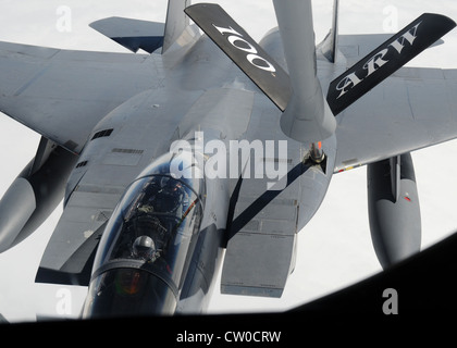 Kapitän John Mcfarland, 494th Fighter Squadron Waffen system Offizier, Uhren, als sein Flugzeug, eine F-15 E Strike Eagle, Kraftstoff erhält von einem 100 Luftbetankung Flügel KC-135 Stratotanker während der Luftbetankung mission Aug 2, 2012, über den Atlantischen Ozean. Mcfarland ist der Bruder von Kapitän Michael Mcfarland, 351 Air Refuelling Squadron und die KC-135 Flugzeuge Commander für diese Mission. Stockfoto