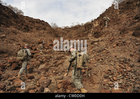 Soldaten der US-Armee aus der 3. Staffel, 124. Kavalleriedivision, Task Force Raptor manövrieren einen Berghang hinauf, während sie am Spornritt der Einheit am 2. August 2012 in den Wüsten von Dschibuti teilnehmen. Der Spornritt ist eine Kavallerietradition, in der ein Trooper eine Reihe von Tests bestehen muss, die körperliche, Führungsqualitäten, technische und taktische Fähigkeiten in einem stark beanspruchten Umfeld bewerten, um seine Spornen zu verdienen und Mitglied des Spur-Ordens zu werden. Die Task Force Raptor wird zur Unterstützung der gemeinsamen Task Force Horn von Afrika eingesetzt. Stockfoto