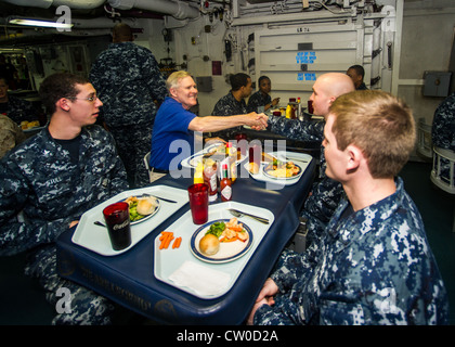 Sekretär der Marine (SECNAV) der ehrenwerte Ray Mabus isst während seines Besuchs an Bord des Flugzeugträgers USS Enterprise (CVN 65) mit der Crew zu Abend. Mabus startete Enterprise während des letzten Einsatzes des Schiffes im Rahmen eines größeren Besuchs in der Region, um mit militärischen und zivilen Führern zu treffen und mit Matrosen und Marineinfanteristen zu sprechen, um ihnen für ihren Dienst zu danken. Stockfoto