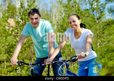 Porträt von zwei jungen Menschen auf Fahrrädern, Blick in die Kamera Stockfoto