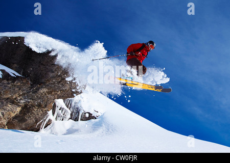 Springen auf verschneiten Hang Skifahrer Stockfoto
