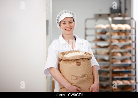 Koch mit Mehlsack in Küche Stockfoto