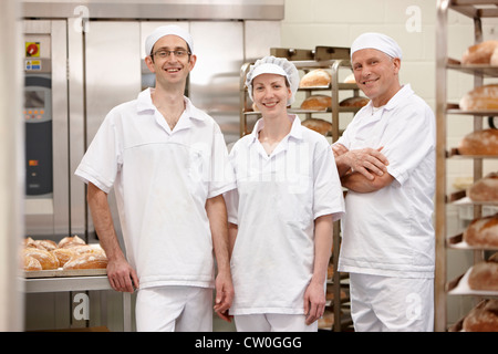 Köche, die lächelnd zusammen in der Küche Stockfoto