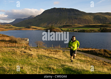 Wanderer, grasbewachsenen Hang hinauf laufen Stockfoto