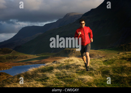 Wanderer auf grasbewachsenen Hang ausgeführt Stockfoto