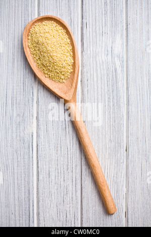 Couscous in Holzlöffel auf Küchentisch Stockfoto